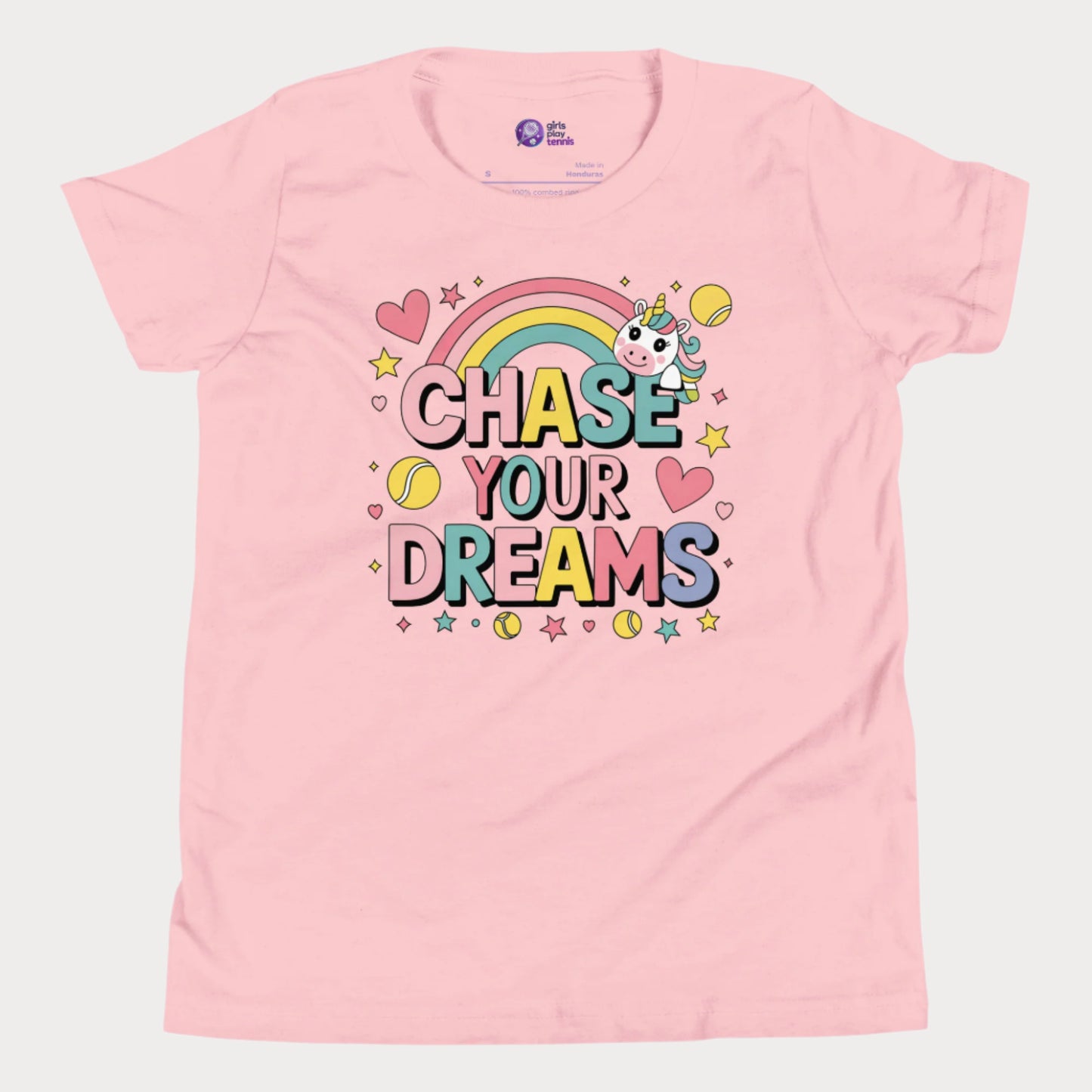 Adorable girls' pink tennis t-shirt featuring a cute unicorn, colorful rainbow, and "Chase Your Dreams" slogan with tennis ball accents.