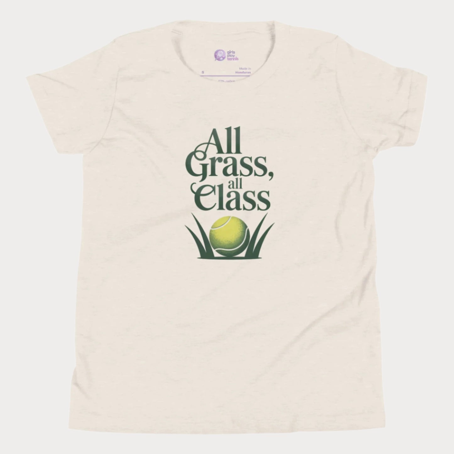Beige girls’ tennis T-shirt with green text “All Grass, All Class” and tennis ball in grass graphic.