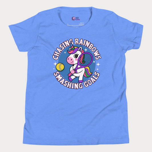 Blue girls' tennis t-shirt featuring a fun and colorful unicorn holding a tennis racket, with the motivational slogan "Chasing Rainbows, Smashing Goals."
