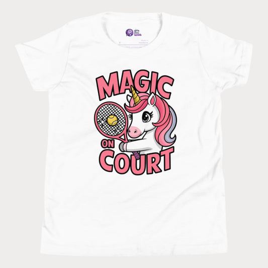White girls' tennis t-shirt featuring a cute unicorn holding a racket with a tennis ball, alongside bold 'Magic on Court' text. Fun and empowering tennis apparel for young girls who love tennis and playful designs.