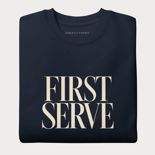 Folded navy First Serve women's tennis crewneck sweatshirt with stacked cream capitals reading First Serve