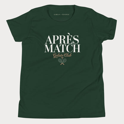 A dark green short-sleeve girls tennis t-shirt with a white and gold graphic on the front reading 'APRÈS MATCH Gelato Club' with crossed tennis rackets, shown on a light gray background.