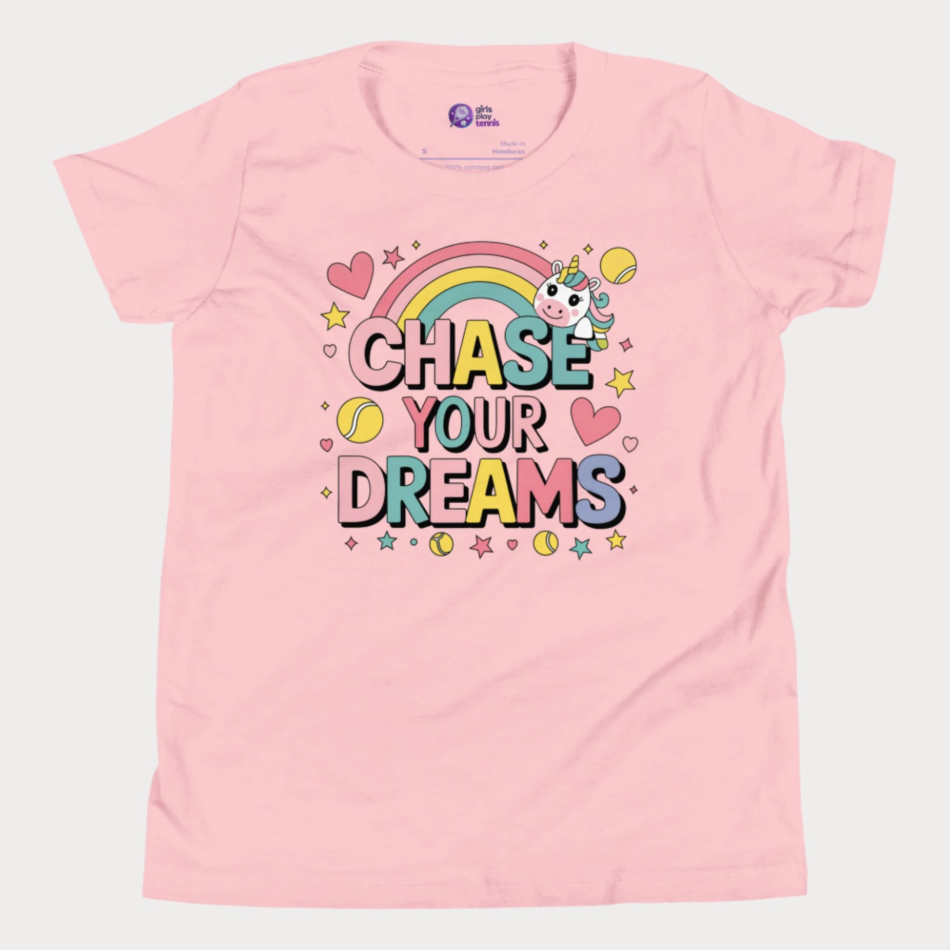 Adorable girls' pink tennis t-shirt featuring a cute unicorn, colorful rainbow, and "Chase Your Dreams" slogan with tennis ball accents.