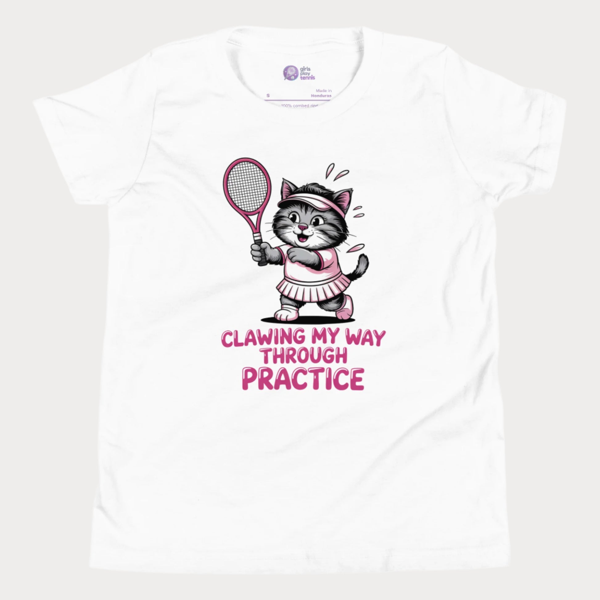 A white girls’ tennis t-shirt featuring a determined gray kitten in a pink tennis outfit holding a pink tennis racket. The kitten is sweating and focused, with the phrase “Clawing My Way Through Practice” in bold pink lettering underneath.