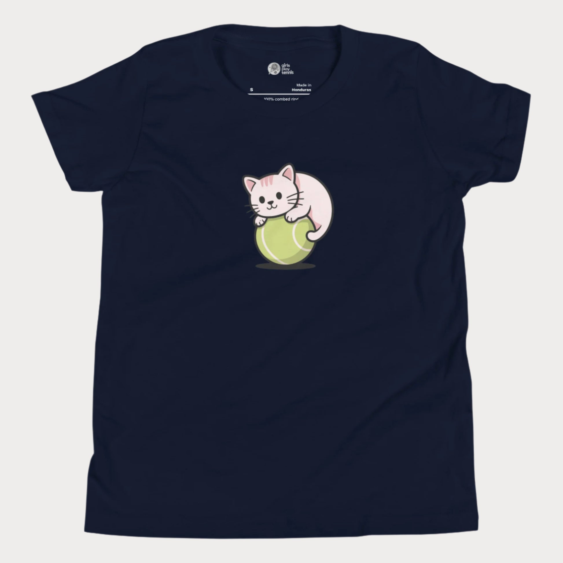 Navy girls’ tennis t-shirt featuring a cute kitten playfully curled around a bright green tennis ball in the center of the chest — a fun and whimsical design perfect for young tennis players who love animals and the game.