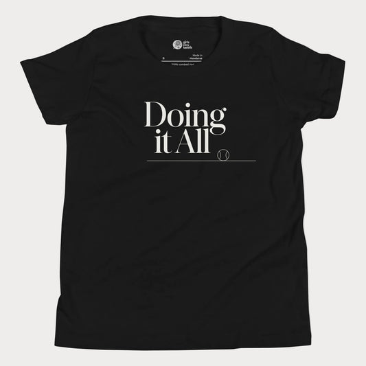 Doing It All tennis tee in black with minimalist white typography and tennis detail for women and girls