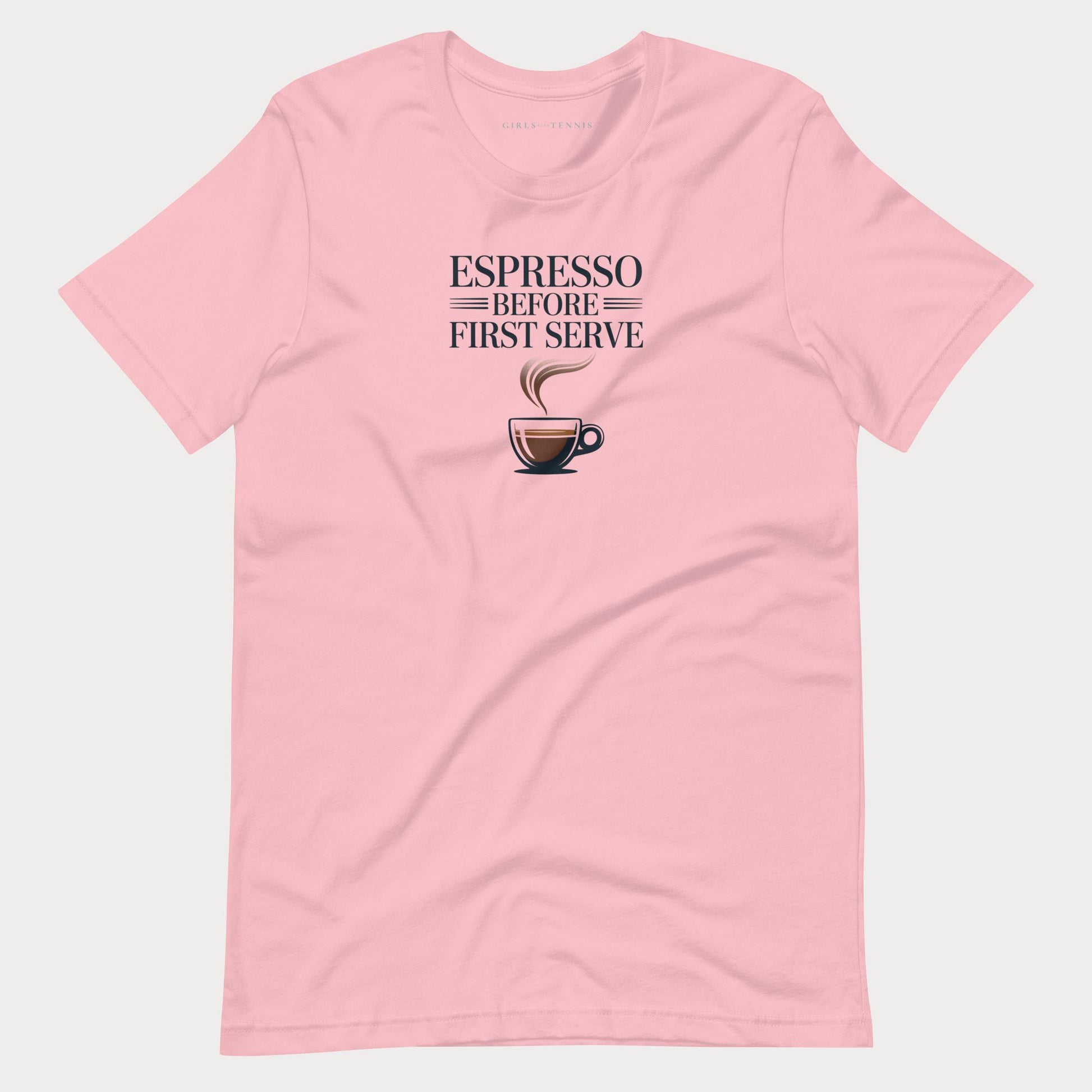 A light pink short-sleeve crewneck tennis lifestyle t-shirt featuring a graphic print on the chest that reads 'ESPRESSO BEFORE FIRST SERVE' above an illustration of a coffee cup with steam.