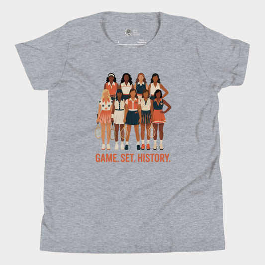 Grey kids tennis t-shirt with illustration of 9 vintage-style female tennis players and the phrase “Game. Set. History.” honoring women’s tennis pioneers.