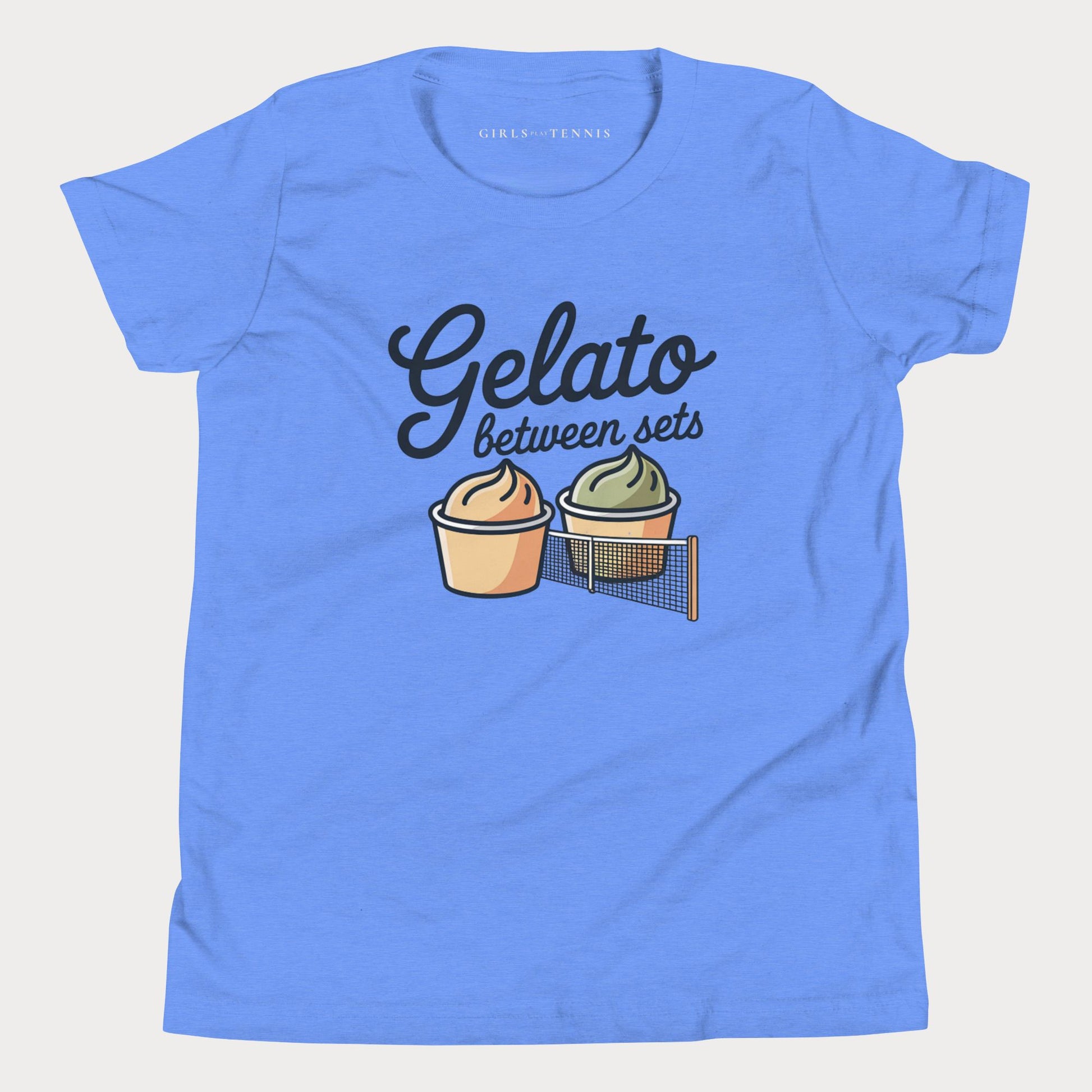 A light blue short-sleeve t-shirt with a graphic print that reads 'Gelato between sets' above two illustrated gelato cups and a tennis net. The inner collar shows the brand name 'GIRLS PLAY TENNIS'.