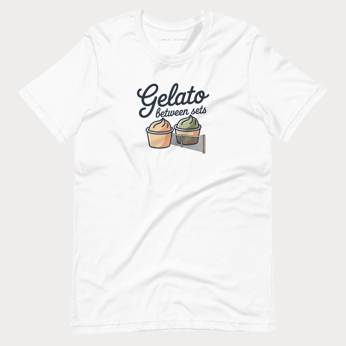 A white short-sleeve crewneck women's tennis t-shirt featuring a graphic print of two gelato cups separated by a net, with the text 'Gelato between sets' written above them.