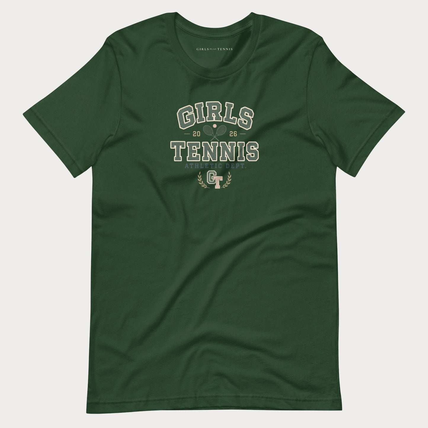 A dark green short-sleeve t-shirt with a distressed white graphic reading 'GIRLS TENNIS' and a small 'GT' logo, displayed flat against a light gray background.
