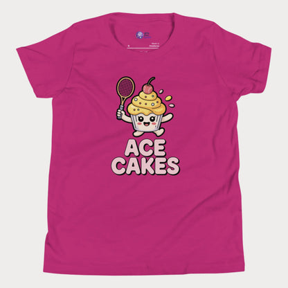 Pink girls tennis t-shirt with a cartoon cake character holding a tennis racket and the text 'ACE CAKES' on a white background.