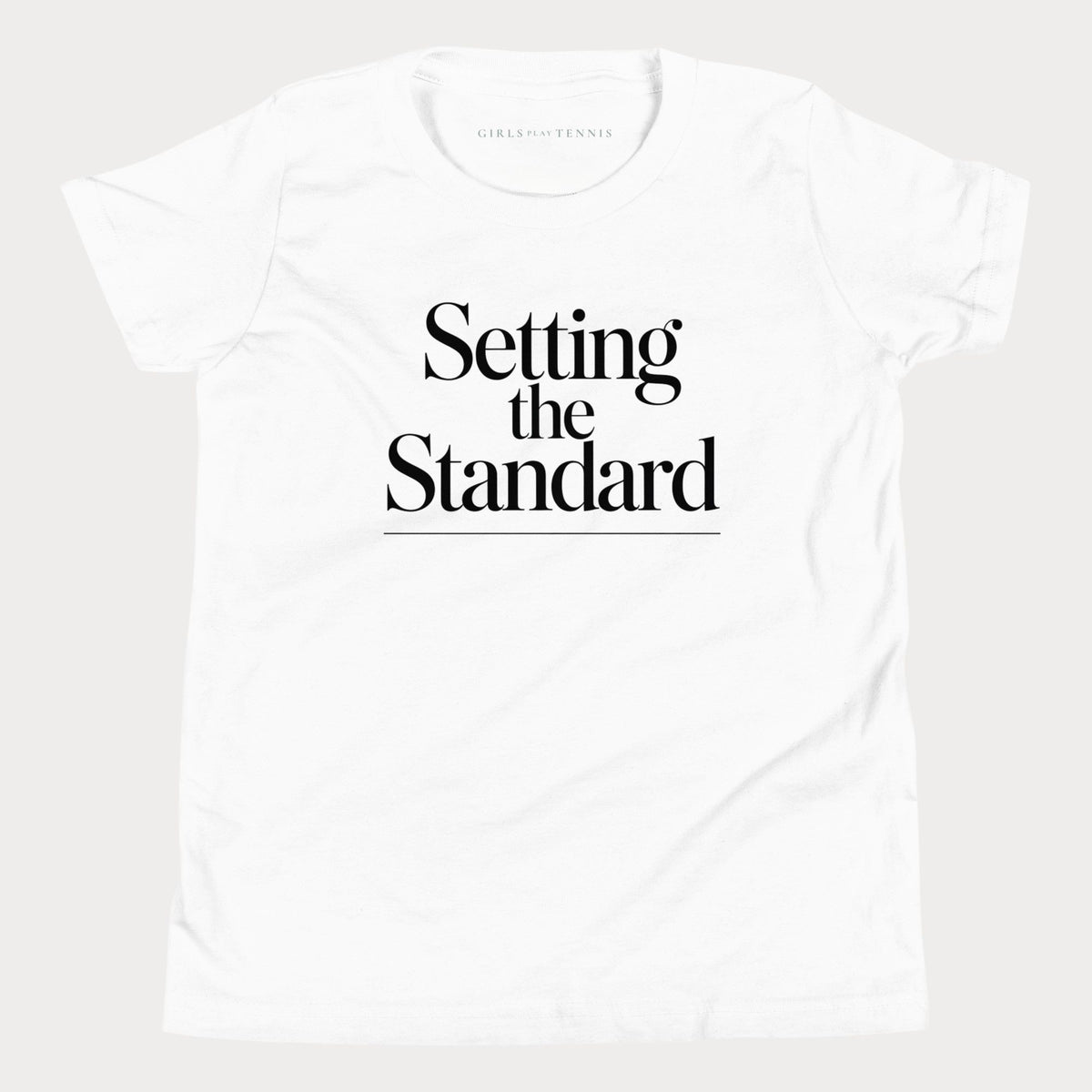 White Setting the Standard girls' tennis T-shirt with stacked serif lettering and a thin underline