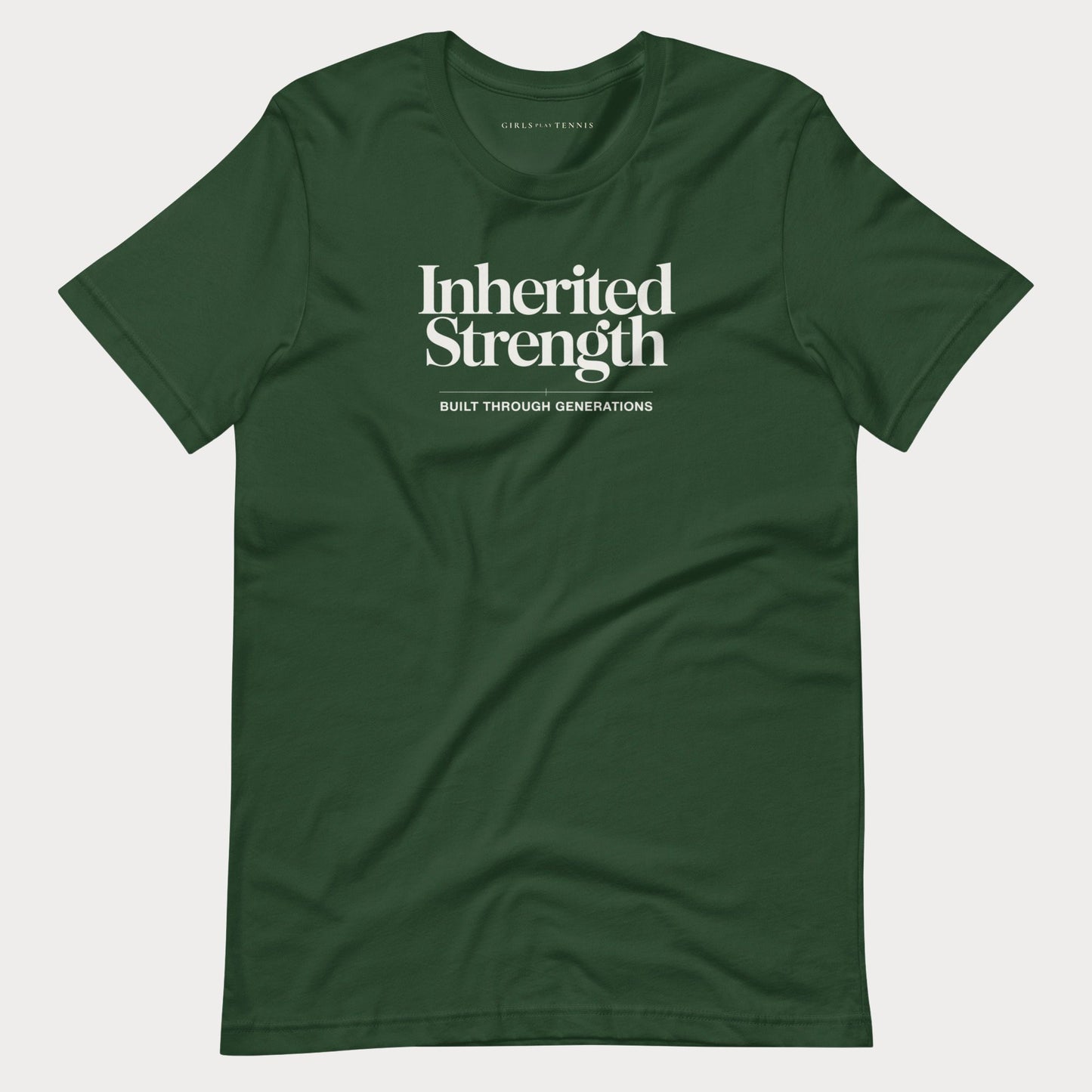 A dark green crewneck women's tennis t-shirt with white text reading 'Inherited Strength' and 'BUILT THROUGH GENERATIONS' on the chest, displayed flat against a light gray background.