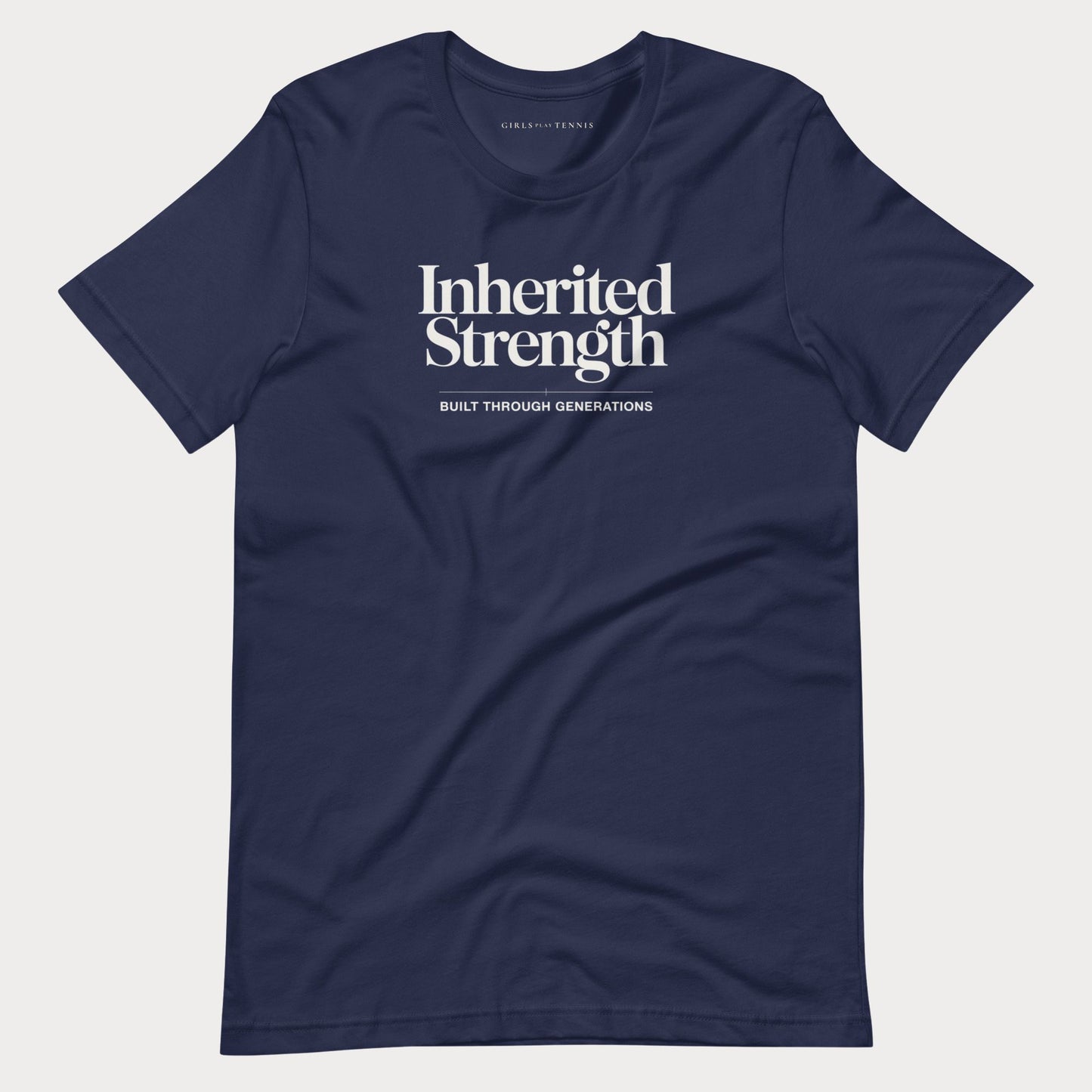 A navy blue short-sleeve crewneck women's tennis t-shirt with white printed text reading 'Inherited Strength' and 'BUILT THROUGH GENERATIONS' on the chest, displayed flat against a light gray background.