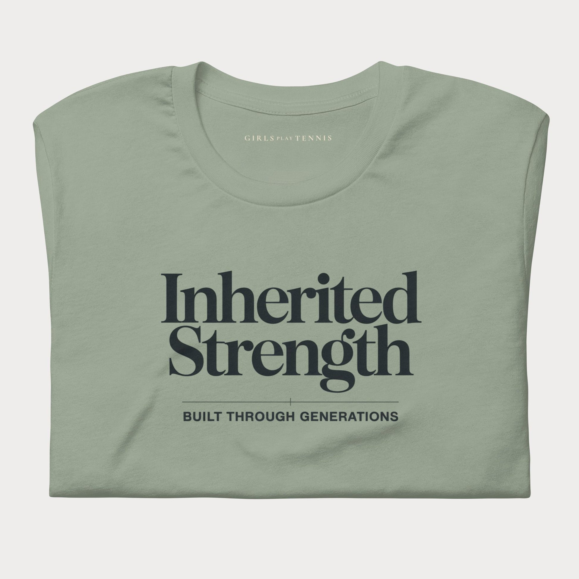 A folded sage green t-shirt with dark navy text reading 'Inherited Strength' and 'BUILT THROUGH GENERATIONS' on the front, displayed against a light gray background.