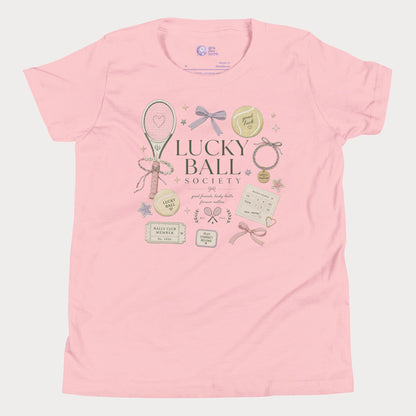 Pink girls tennis tee featuring lucky ball society artwork with bows, bracelets, and vintage tennis lifestyle details