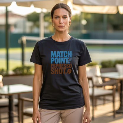 A women standing in a coffee shop next to a tennis court, wearing black tennis t-shirt with Match Point Espresso Shot typography design for fans for tennis and coffee.