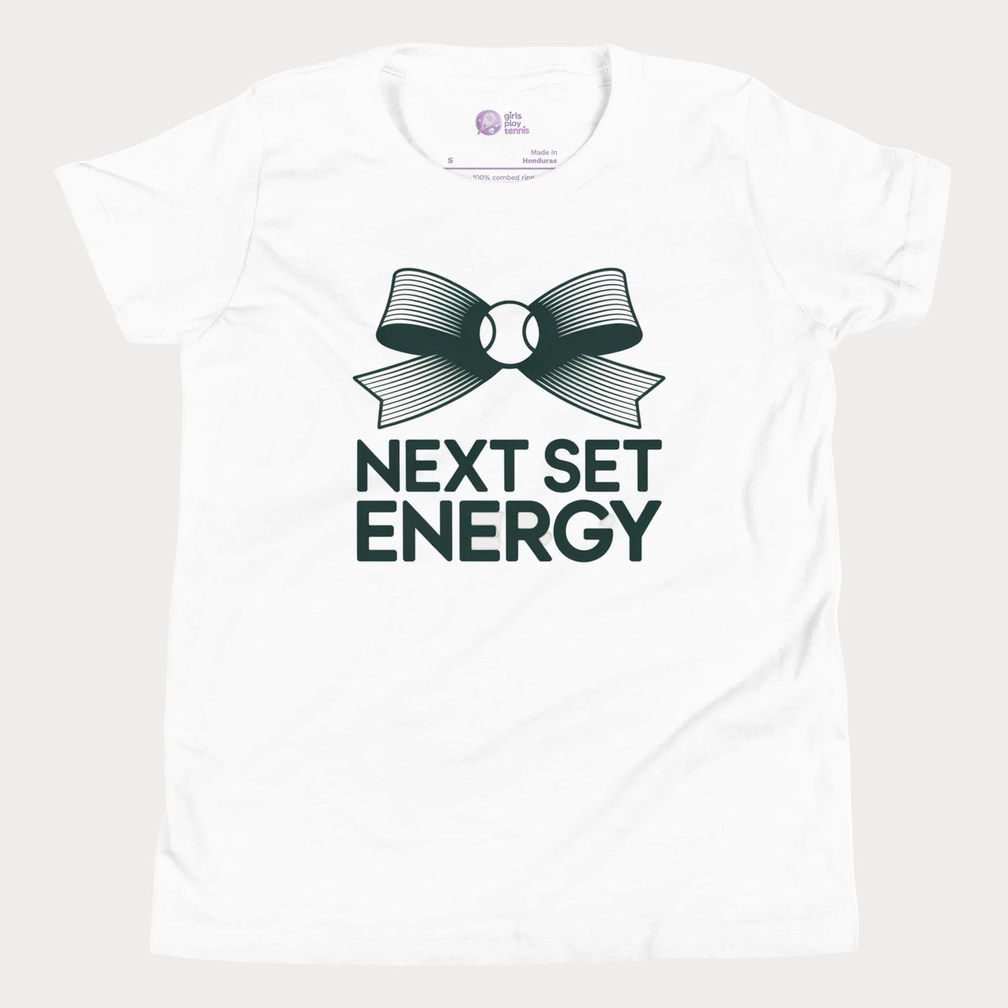 Next Set Energy tennis tee in white with green bow and bold typography design for girls and women
