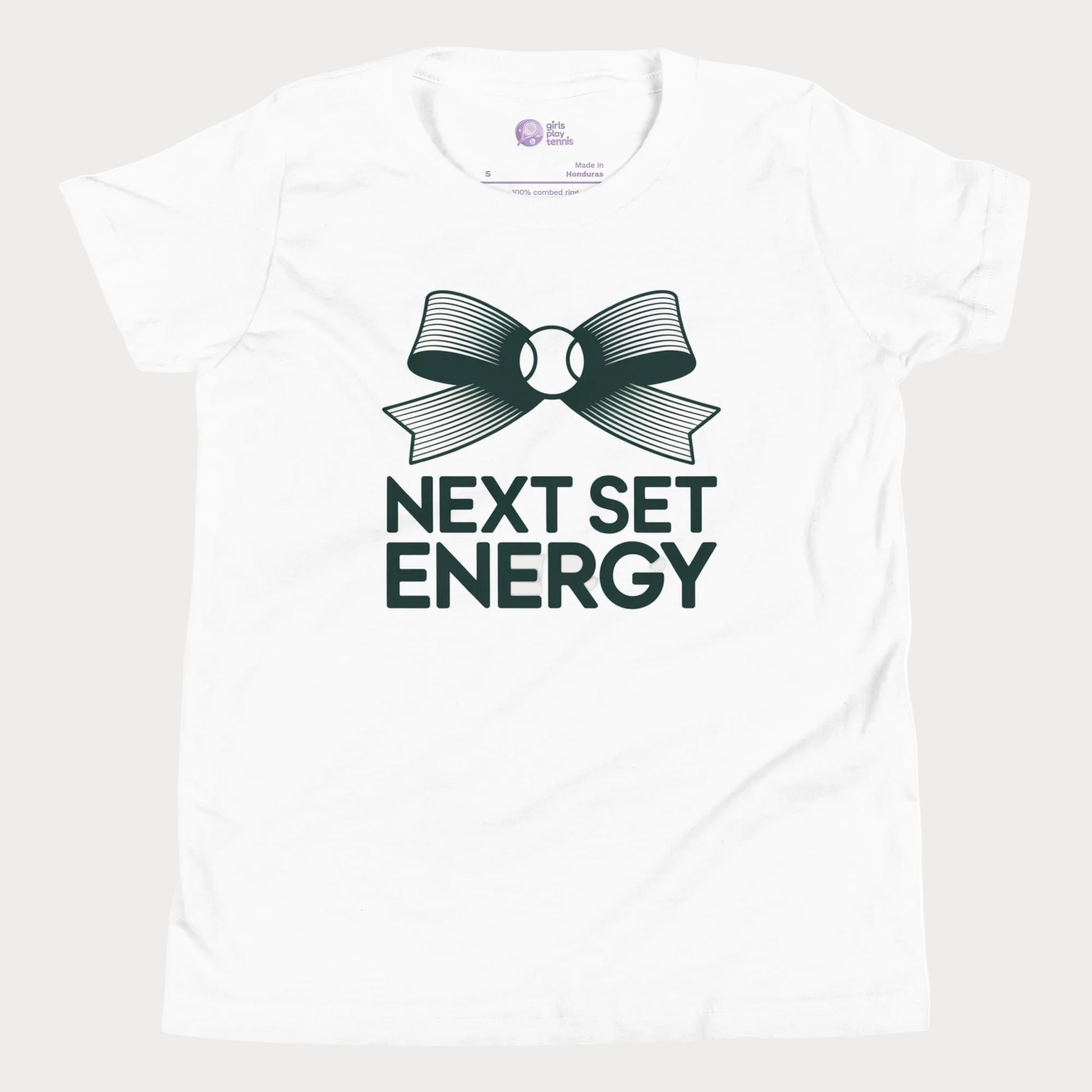 Next Set Energy tennis tee in white with green bow and bold typography design for girls and women