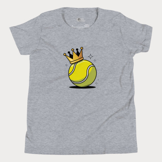 A heather grey girls’ tennis t-shirt featuring a bold yellow tennis ball with a golden crown perched on top. This playful design celebrates young girls who rule the court with power and personality.
