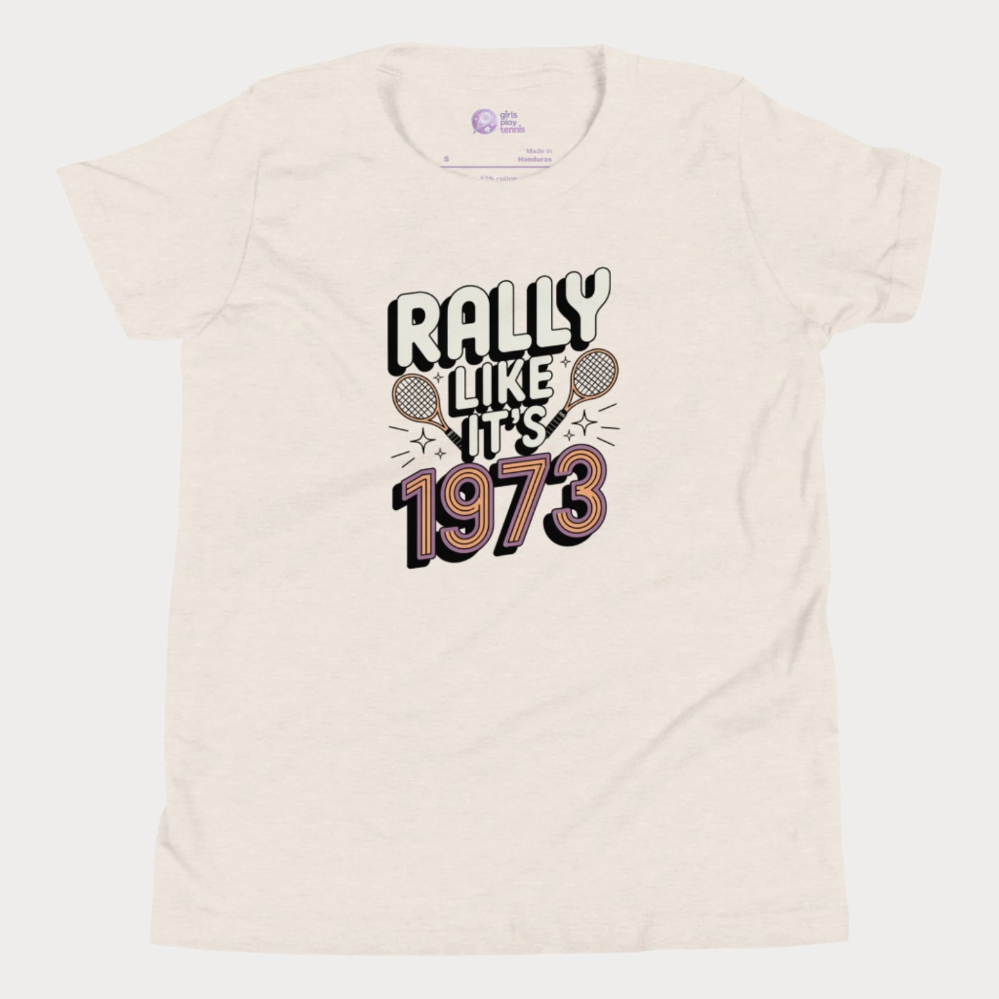 Beige girls tennis t-shirt with retro slogan ‘Rally Like It’s 1973’ and crossed tennis rackets