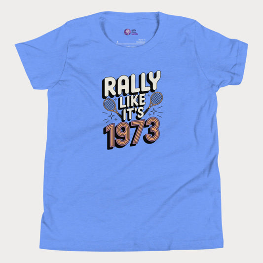 Blue girls tennis t-shirt with retro slogan ‘Rally Like It’s 1973’ and crossed tennis rackets