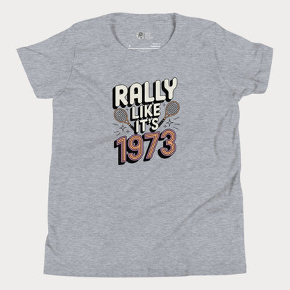 Grey girls tennis t-shirt with retro slogan ‘Rally Like It’s 1973’ and crossed tennis rackets