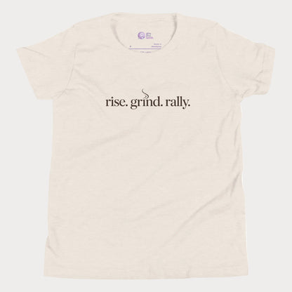 Beige tennis t-shirt with Rise Grind Rally slogan across the chest – Girls Play Tennis apparel.