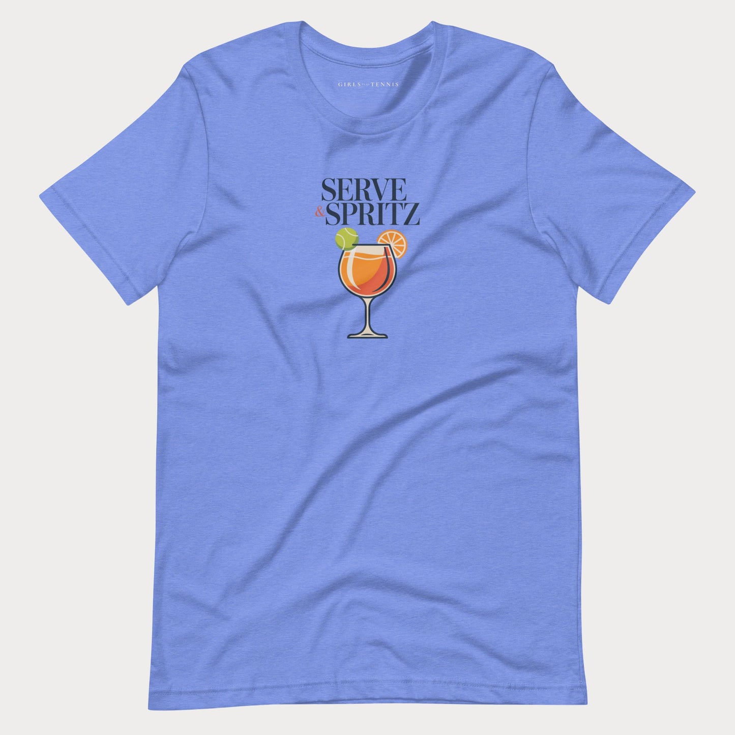 A blue-colored short-sleeve tennis lifestyle t-shirt with a graphic on the chest that reads 'SERVE & SPRITZ' above an illustration of a cocktail with a tennis ball and orange slice.