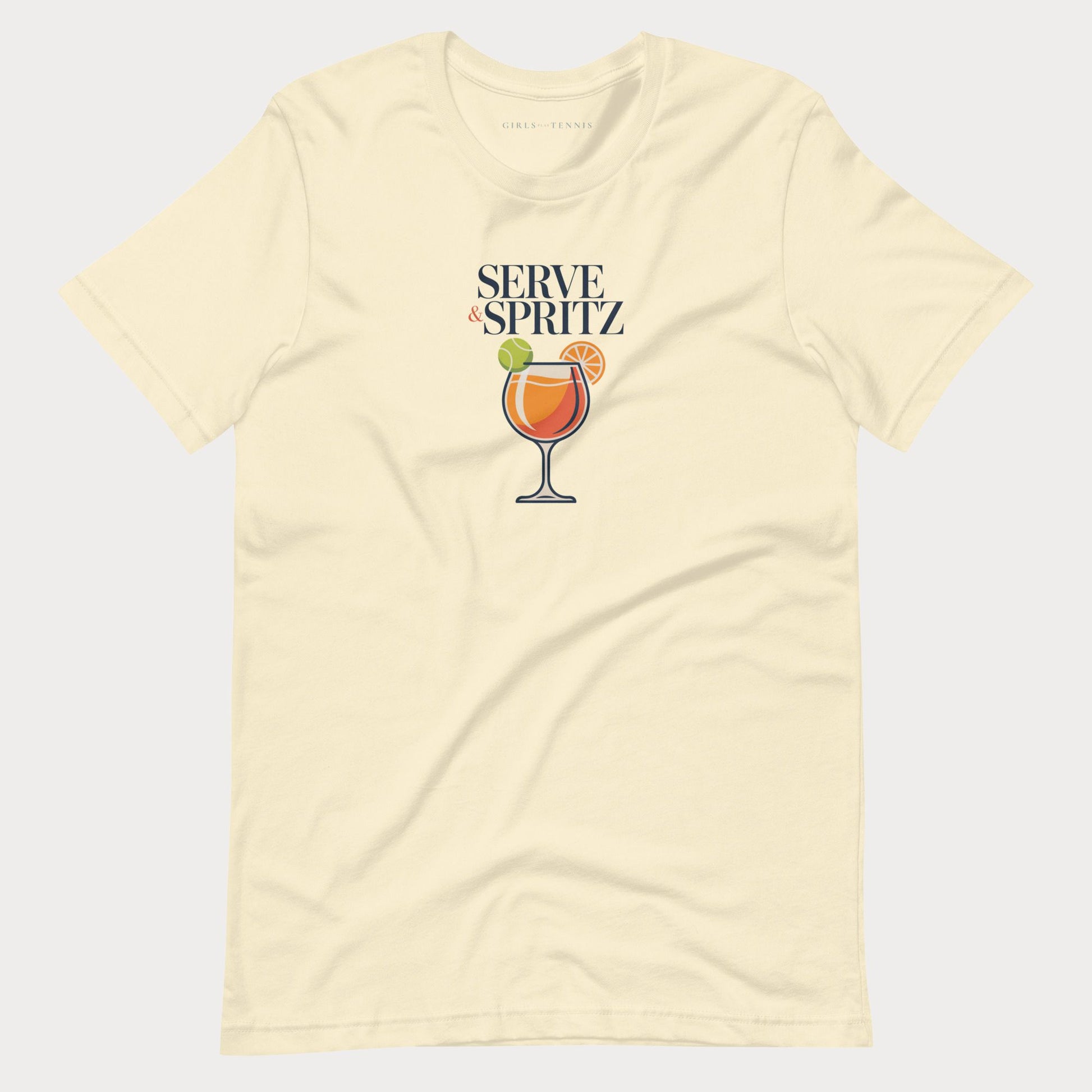 A cream-colored short-sleeve tennis lifestyle t-shirt with a graphic on the chest that reads 'SERVE & SPRITZ' above an illustration of a cocktail with a tennis ball and orange slice.