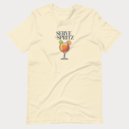 A cream-colored short-sleeve tennis lifestyle t-shirt with a graphic on the chest that reads 'SERVE & SPRITZ' above an illustration of a cocktail with a tennis ball and orange slice.