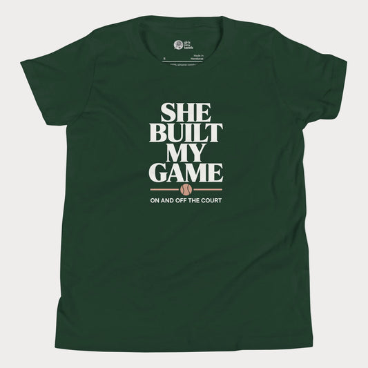 She Built My Game tennis t-shirt in black with white typography and tennis graphic for girls and women.