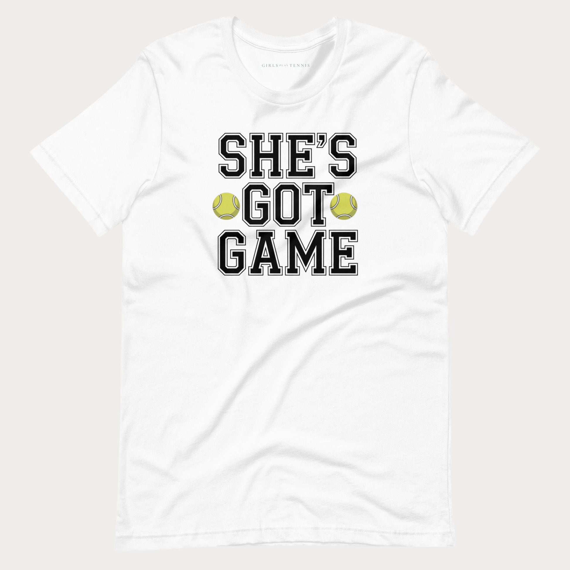 A white short-sleeve crewneck women's tennis t-shirt featuring the text 'SHE'S GOT GAME' in a black varsity-style font with a white outline, accented by two yellow-green tennis balls between the words 'GOT' and 'GAME'.