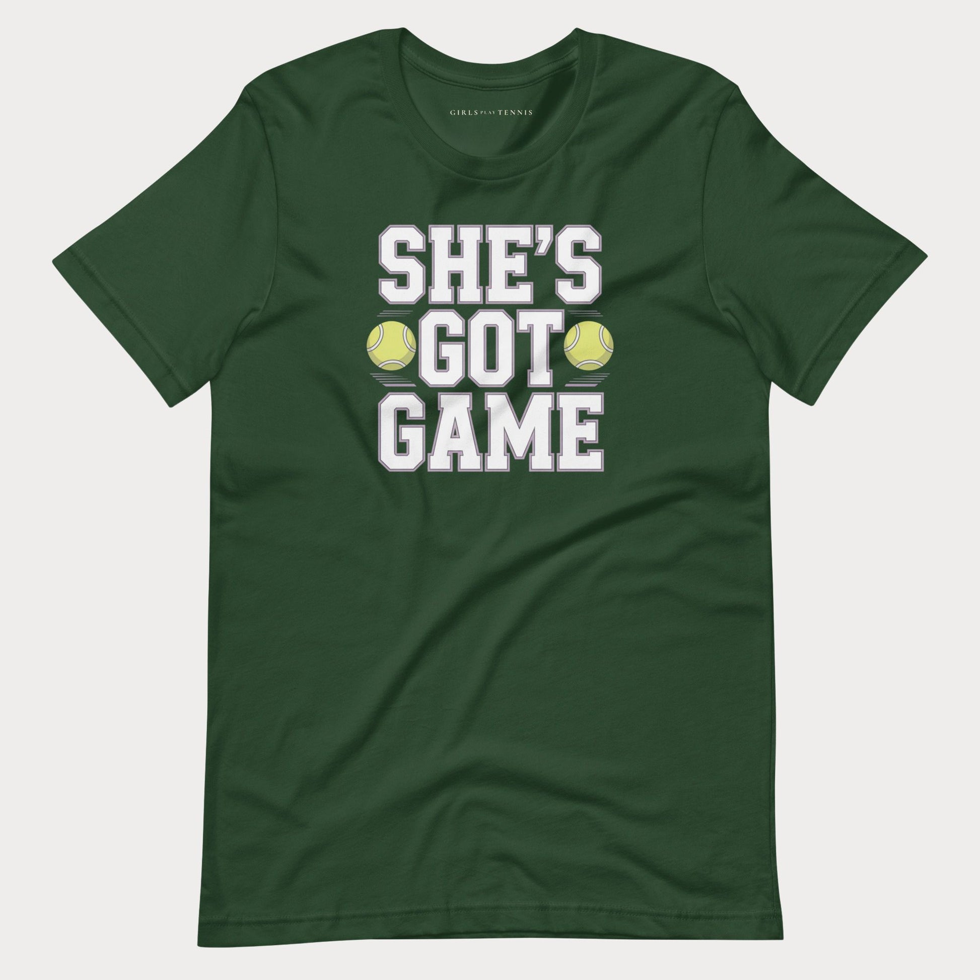 A dark green short-sleeve women's tennis t-shirt with a graphic print on the front that reads 'SHE'S GOT GAME' in white block letters, with two yellow tennis balls replacing the 'O' in 'GOT'.