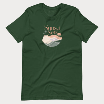 A forest green short-sleeve crewneck women's lifestyle tennis t-shirt featuring a 'Sunset Sets' graphic on the chest with a stylized beach scene and shell illustration, displayed flat against a light gray background.