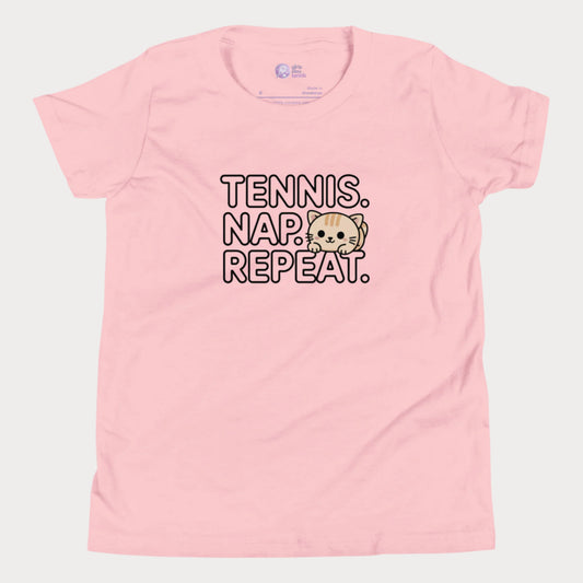 Pink kids tennis t-shirt with “Tennis. Nap. Repeat.” text and a cute cartoon cat illustration, part of the Girls Play Tennis apparel line.
