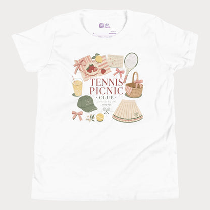 Girls tennis tee featuring picnic-inspired tennis lifestyle artwork with strawberries, lemonade, bows, and pleated skirt details