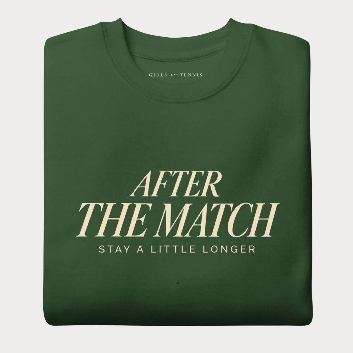 Folded forest green After the Match women's tennis crewneck sweatshirt with cream lettering reading After the Match above Stay a Little Longer