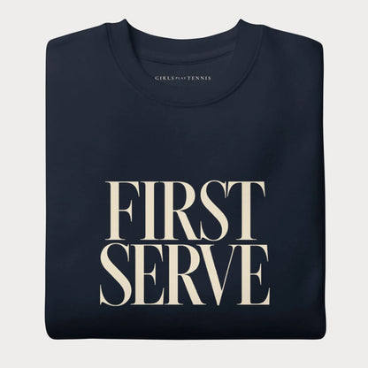 Folded navy First Serve women's tennis crewneck sweatshirt with stacked cream capitals reading First Serve