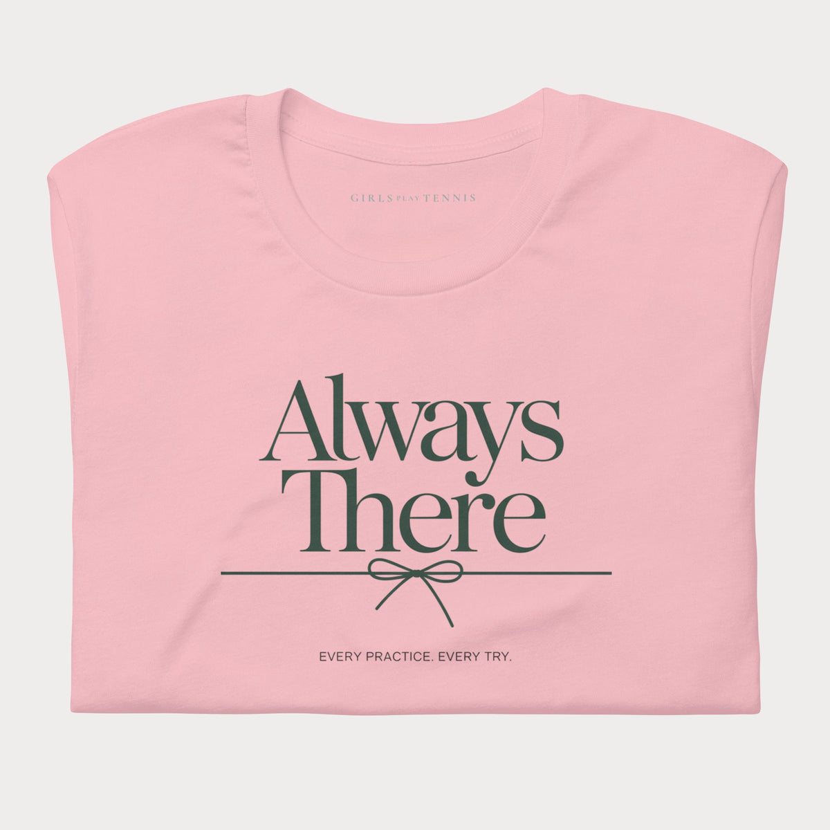 Folded pink Always There women's tennis T-shirt with a bow-tied line and "Every practice. Every try." tagline