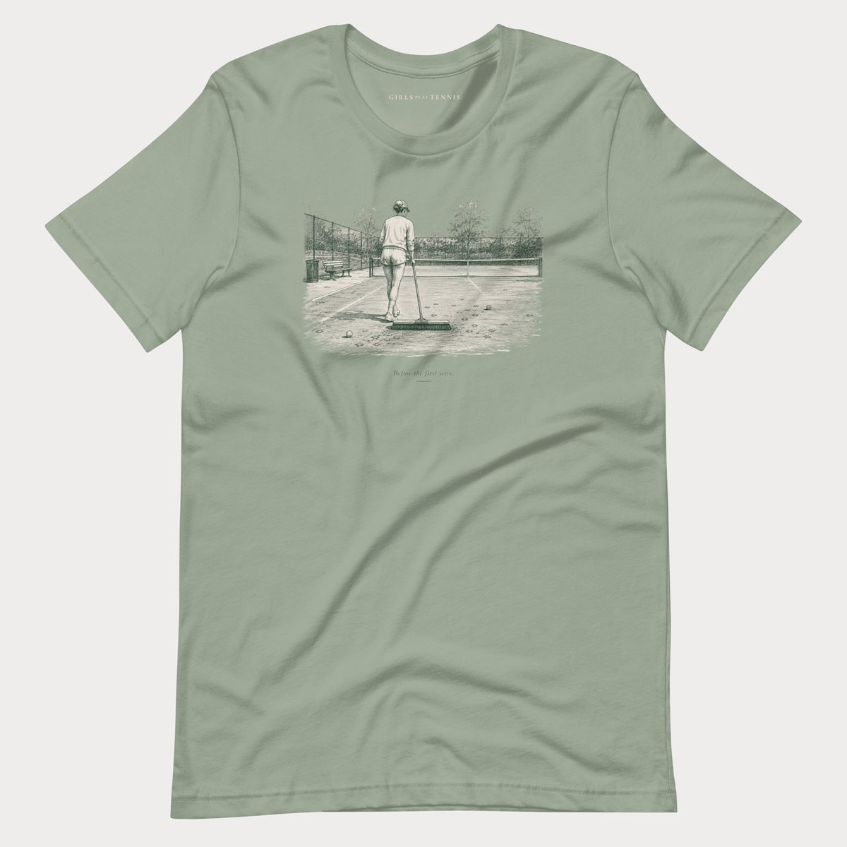 Sage green Before the First Serve women's tennis T-shirt with a pen-and-ink illustration of a person brushing a tennis court with a large broom