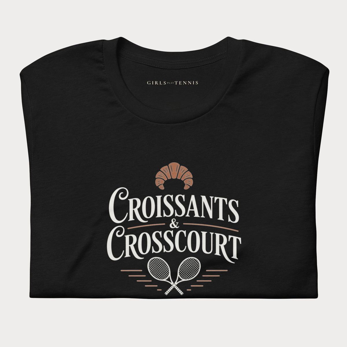Folded black Croissants & Crosscourt women's tennis T-shirt with a croissant above crossed rackets