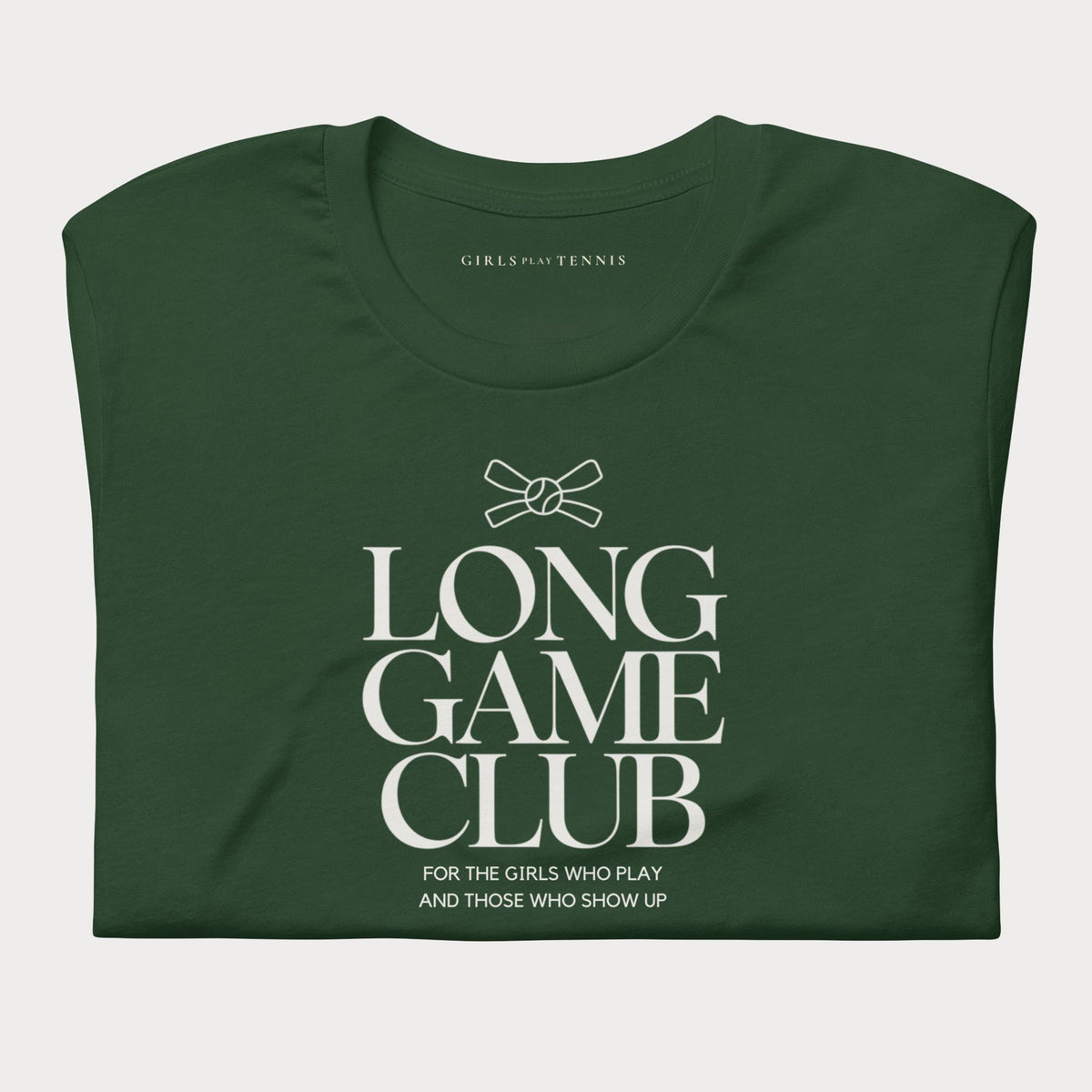 Folded forest green Long Game Club women's tennis T-shirt with stacked lettering and a small bow