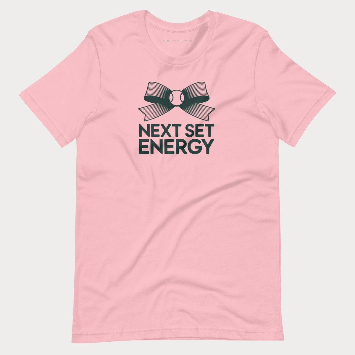 Pink Next Set Energy women's tennis T-shirt with a bow around a tennis ball above bold lettering