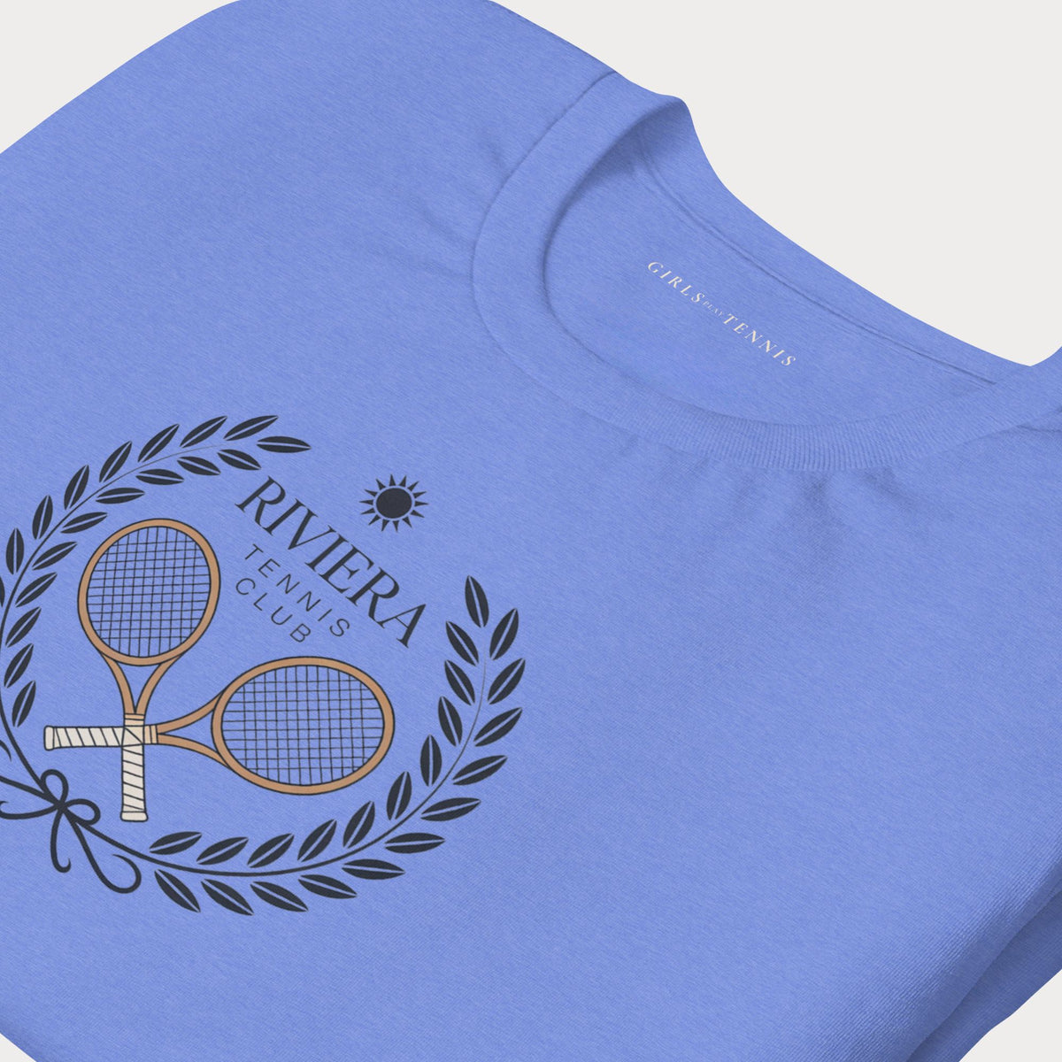 Close-up of the Riviera Tennis Club laurel wreath and crossed rackets on a blue tee
