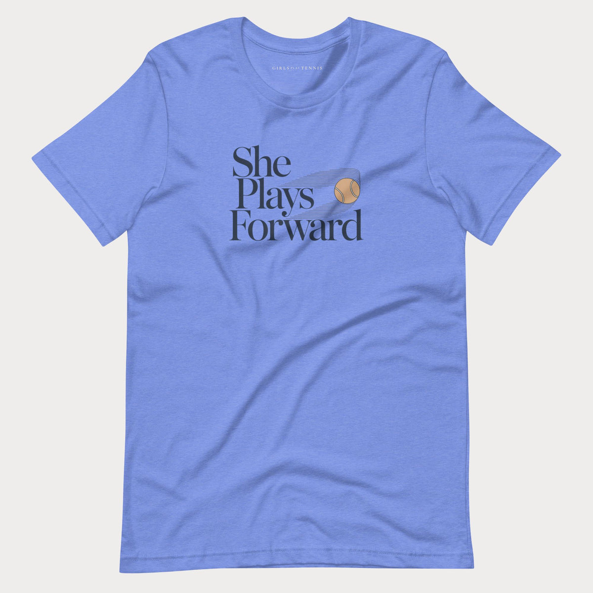Blue She Plays Forward women's tennis T-shirt with stacked lettering and a motion-blurred tennis ball