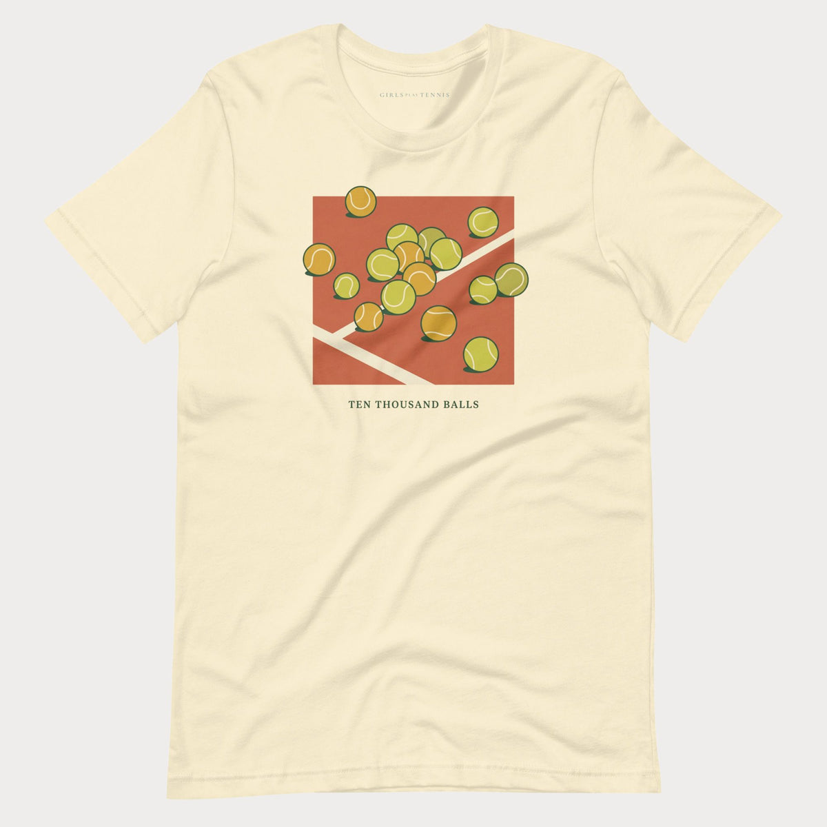 Cream Ten Thousand Balls women's tennis T-shirt with a clay-red square covered in scattered tennis balls
