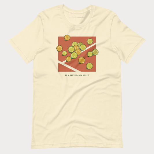 Cream Ten Thousand Balls women's tennis T-shirt with a clay-red square covered in scattered tennis balls