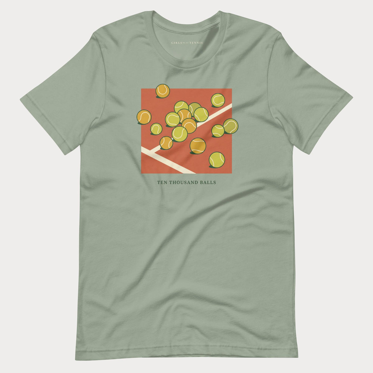 Sage green Ten Thousand Balls women's tennis T-shirt with a clay-red square covered in scattered tennis balls